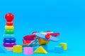 Baby kid toy background. Wooden toy plane, baby stacking rings pyramid and colorful blocks on blue background Royalty Free Stock Photo