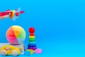 Baby kid toy background. Wooden toy plane, baby stacking rings pyramid and colorful blocks on blue background Royalty Free Stock Photo