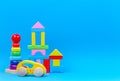 Baby kid toy background. Wooden toy train, baby stacking rings pyramid and colorful blocks on blue background Royalty Free Stock Photo