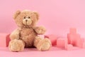 Baby kid toys background. Blue empty rectangle podium platform stand, teddy bear and pink wooden toy blocks on pastel Royalty Free Stock Photo