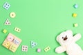 Baby kid toys background. Teddy bear and wooden pastel color geometry educational toy for children on light green Royalty Free Stock Photo