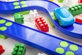 Baby kid toys background. Toy car  plastic road and colorful blocks on white wooden background Royalty Free Stock Photo