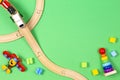 Baby kid toys background. Toy train, red airplane, wooden stacking pyramid tower and colorful blocks on light green Royalty Free Stock Photo