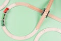 Baby kid toys background. Toy train and wooden rails on light green background. Top view, copy space Royalty Free Stock Photo