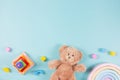 Baby kids educational toys frame background. Teddy bear, wooden stacking pyramide tower, toy rainbow and colorful blocks