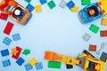 Baby kids toy frame. Top view multicolor cubes bricks and cars on blue background. Blocks flat lay. Copy spase for text