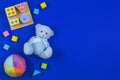 Baby kids toys background. Blue teddy bear, colorful wood blocks, shape color recognition puzzle stacker on navy blue Royalty Free Stock Photo