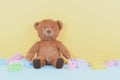 Baby kids toys background with brown teddy bear and colorful building blocks bricks on pastel yellow and blue background Royalty Free Stock Photo