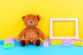 Baby kids toys background with empty picture frame, teddy bear and colorful building blocks bricks Royalty Free Stock Photo