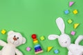 Baby kids toys background with teddy bear, soft plush toys, wooden toys and blocks on light green background.