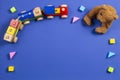 Baby kids toys background. Teddy bear, wooden train and colorful blocks on navy blue background Royalty Free Stock Photo