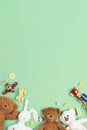 Baby kids toys background. Teddy bears, wooden train, toy cars, colorful blocks on light green background. Top view Royalty Free Stock Photo