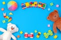 Baby kids toys background. Two teddy bears, wooden train, toy cars, colorful blocks on blue background Royalty Free Stock Photo