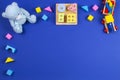 Baby kids toys background. Wooden train, blue teddy bear and colorful blocks on navy blue background Royalty Free Stock Photo