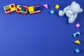 Baby kids toys background. Wooden train, blue teddy bear and colorful blocks on navy blue background Royalty Free Stock Photo