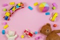 Baby kids toys frame with teddy bear, toy car, wooden train, colorful bricks on pink background. Top view Royalty Free Stock Photo