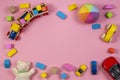 Baby kids toys frame with teddy bear, toy car, wooden train, colorful bricks on pink background. Top view Royalty Free Stock Photo