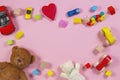 Baby kids toys frame with teddy bear, wooden toy car, colorful bricks on pink background. Top view Royalty Free Stock Photo