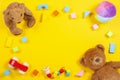 Baby kids toys frame with teddy bear, wooden toy car, colorful bricks on yellow background. Top view Royalty Free Stock Photo