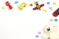 Baby kids toys frame with toy cars, teddy bear, colorful plane, wooden bricks on white background. Top view, flat lay Royalty Free Stock Photo