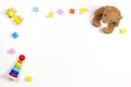 Baby kids toys frame on white background with teddy bear, wooden car, toy pyramid and colorful building blocks. Top view Royalty Free Stock Photo