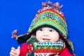 Baby in a knitted colorful hat and scarf on a blue blanket Royalty Free Stock Photo