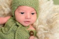 Baby in a knitted green outfit, closeup Royalty Free Stock Photo