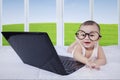 Baby with laptop laughing on bed Royalty Free Stock Photo