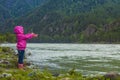 The baby launches a paper boat in a mountainous river Royalty Free Stock Photo