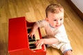 Baby learning to play the piano with a wooden toy instrument, a tender and funny childhood scene