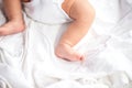 Baby legs and bottom in diaper on white bed background, top view, copy space Royalty Free Stock Photo