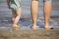 Baby legs and feet with mum legs on the shore of a beach Royalty Free Stock Photo