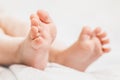 Baby legs lie on the bed on a white background. close up Royalty Free Stock Photo