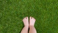 Baby legs standing on green grass