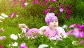 The baby lies on the grass in flowers