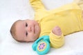 The baby lies with toy phone on a white background Royalty Free Stock Photo