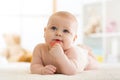 Baby little child bites teether lying on bed weared diaper Royalty Free Stock Photo