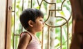 Baby looking out window and waiting for mother to come home. Asian Indian boy, 2 years Old Royalty Free Stock Photo