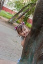 Baby looks out from behind a tree. funny playful baby Royalty Free Stock Photo