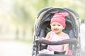 Baby lovely girl smiling and looking up to camera outdoors. Beautiful asian 6 months infant having happy time in the park