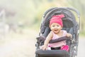 Baby lovely girl smiling and looking up to camera outdoors. Beautiful asian 6 months infant having happy time in th park