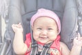 Baby lovely girl smiling and looking up to camera outdoors. Beautiful asian 6 months infant having happy time in th park