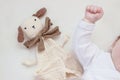 Baby lying in bed with cute muslin cuddly toy Royalty Free Stock Photo