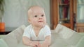 Baby Lying in Bed on its Belly at Home. Mouth Open Royalty Free Stock Photo