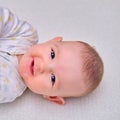 Baby is lying on the floor and smiling. Happy four-month-old child on the carpet Royalty Free Stock Photo