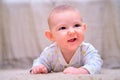 Baby is lying on the floor and smiling. Happy four-month-old child on the carpet Royalty Free Stock Photo