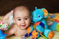 The baby is lying on his tummy hugging a toy elephant. Royalty Free Stock Photo