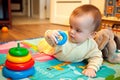 Baby lying on his tummy and playing with pyramid