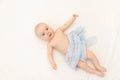 A baby is lying on a white background. Bedding for children. 6 months. Healthy baby in the crib. Space for text