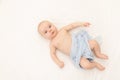 A baby is lying on a white background. Bedding for children. 6 months. Healthy baby in the crib. Space for text